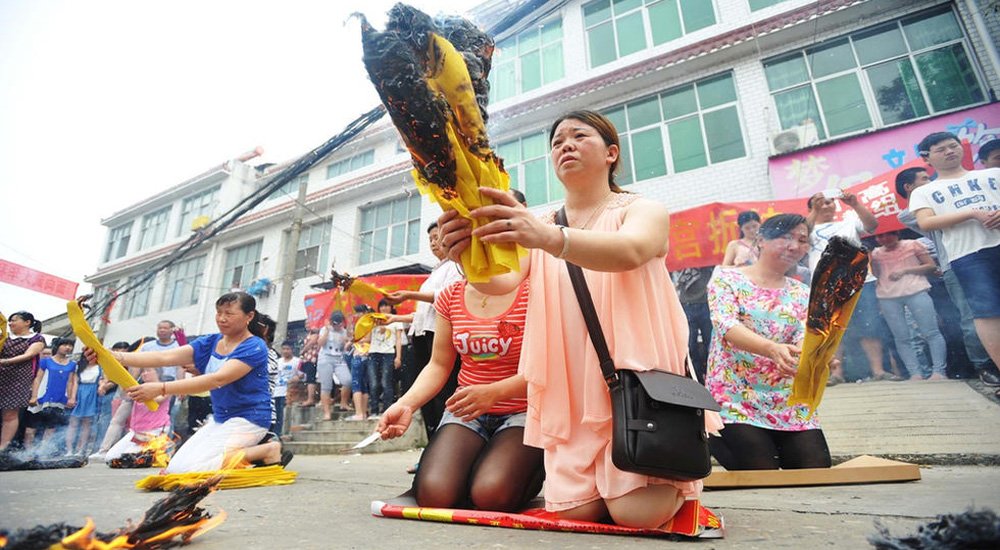 孩子参加高考，家长沿街烧纸跪拜