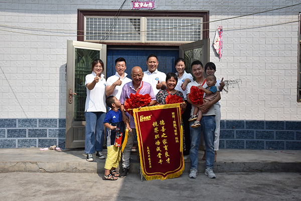 为老人颁发“德善之家育良才,视界职场成骨干”的锦旗